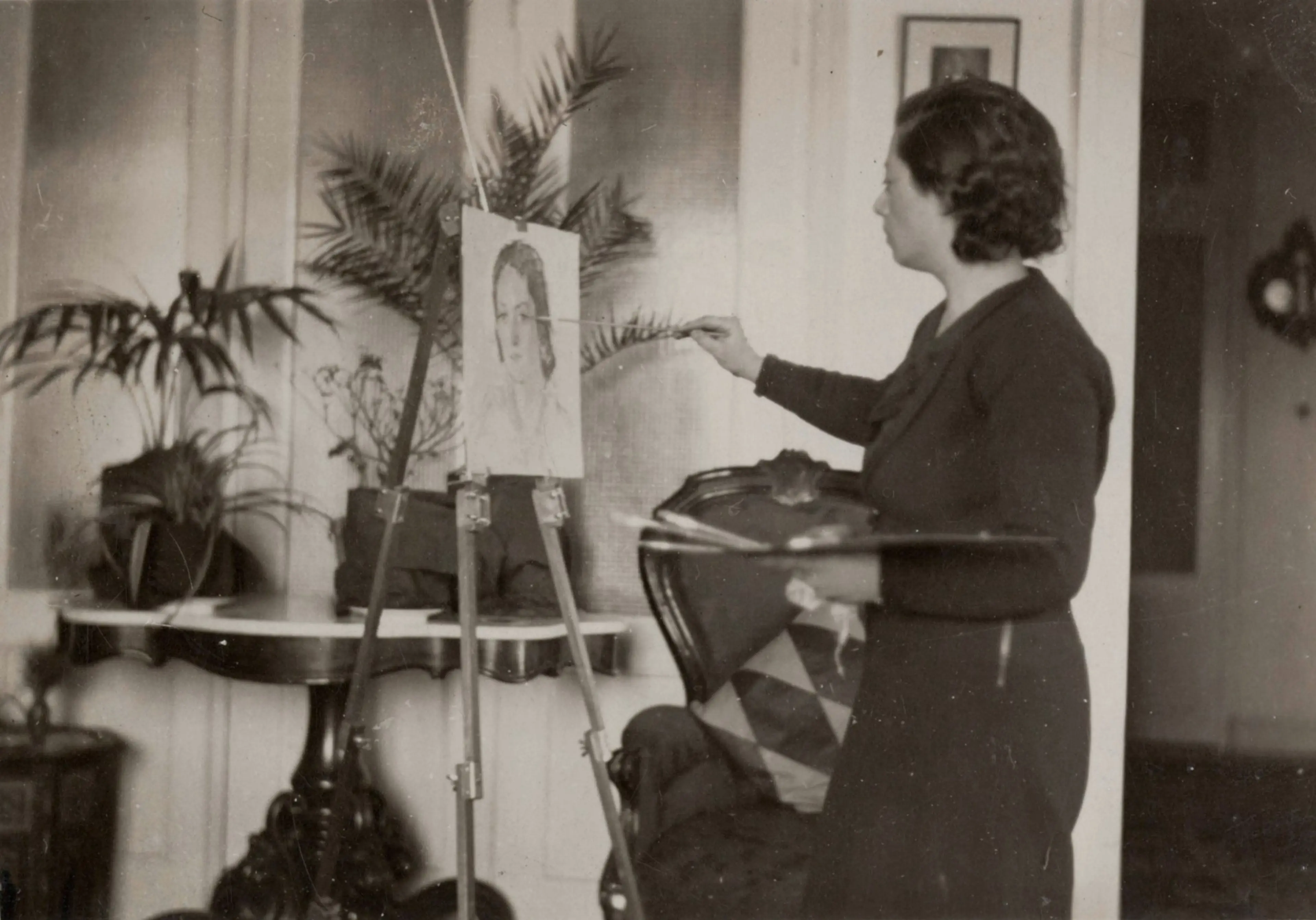Sabiha Bozcalı in front of an easel working on a portrait of a woman Salt Research, Sabiha Rüştü Bozcalı Archive