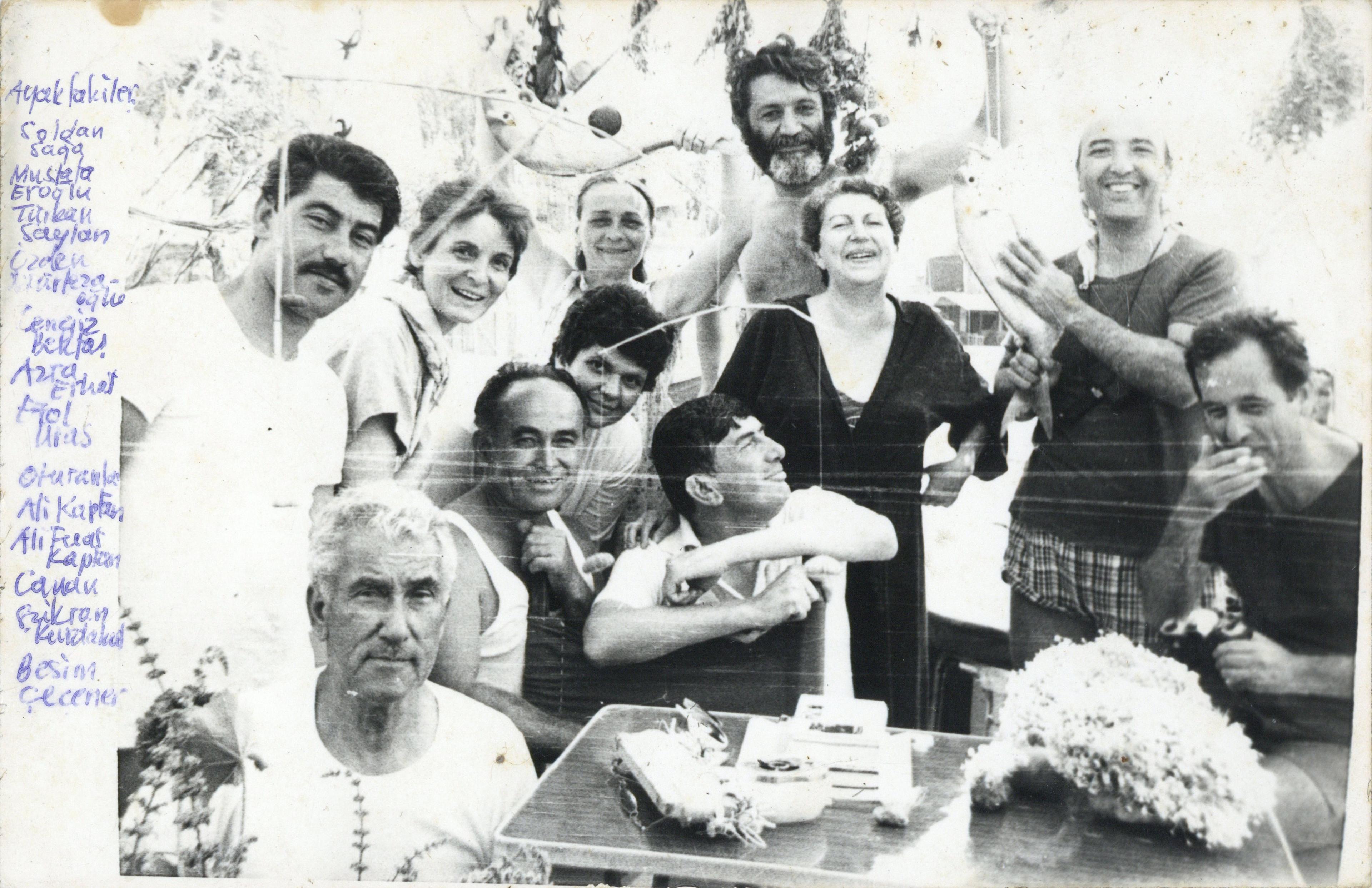 Azra Erhat, Cengiz Bektaş ve arkadaşları Mavi Yolculuk'ta, 1981 (Fotoğrafın arkasında “1981 Mavi yolcular bereketli balık avı sonrası” yazılı) Salt Araştırma, Cengiz Bektaş Arşivi