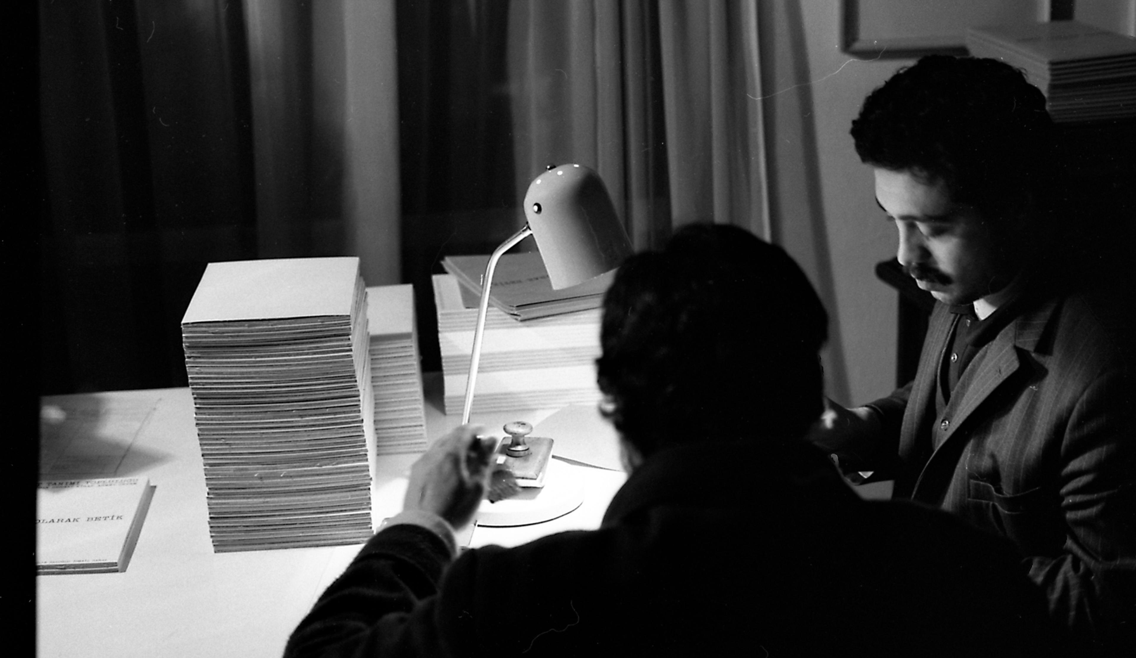 Alparslan Baloğlu (on the right) during the preparation of the exhibition Sanat Olarak Betik [Book as Art], Art Definition Group’s workspace (Taksim, Istanbul), 1980 Salt Research, Ahmet Öktem Archive