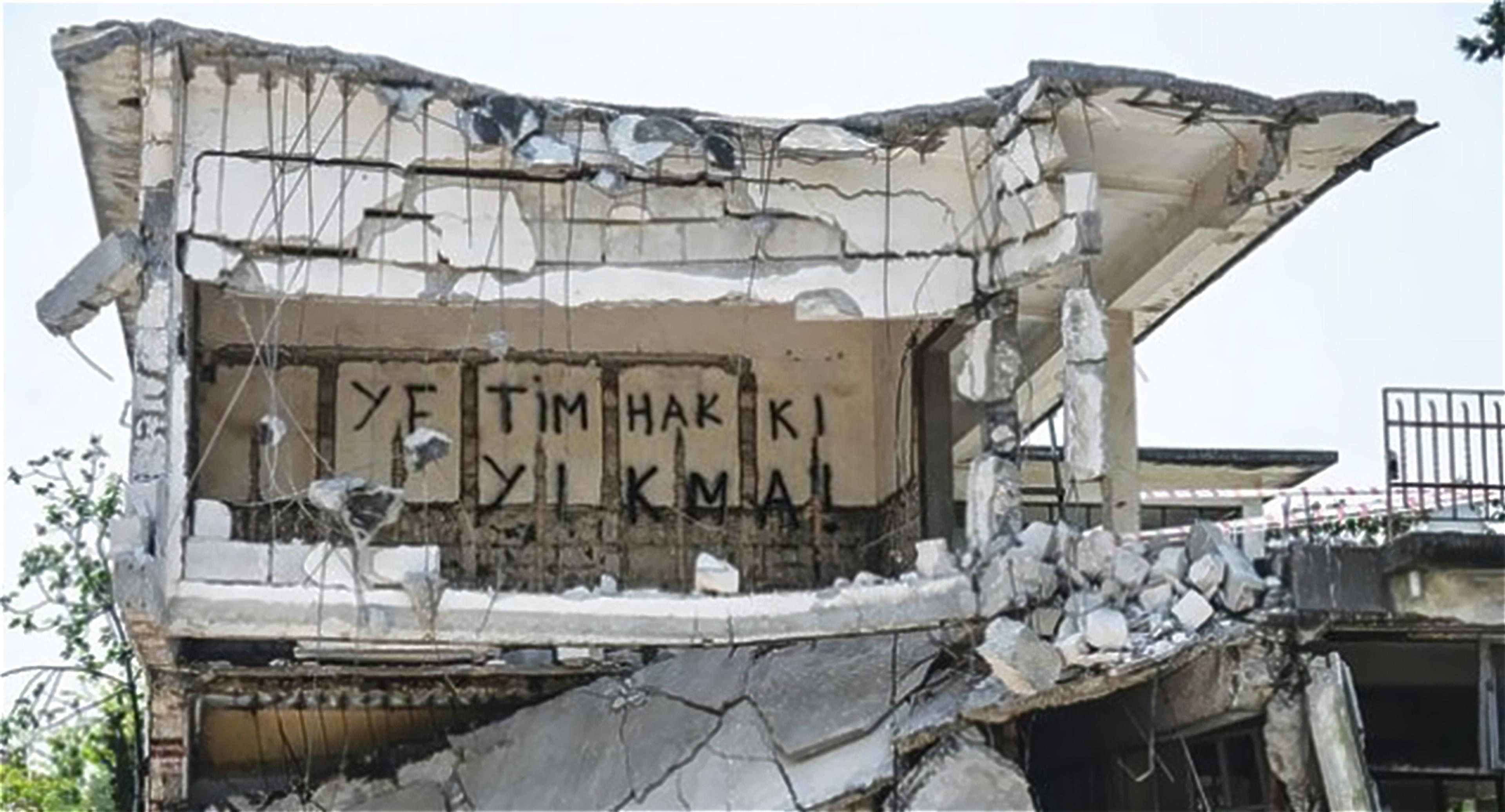 Görsel 1 Bir kısmı yıkılmış Kamp Armen yapısı ve duvarına yazılmış slogan, 2015 (Kaynak: agos.com.tr)