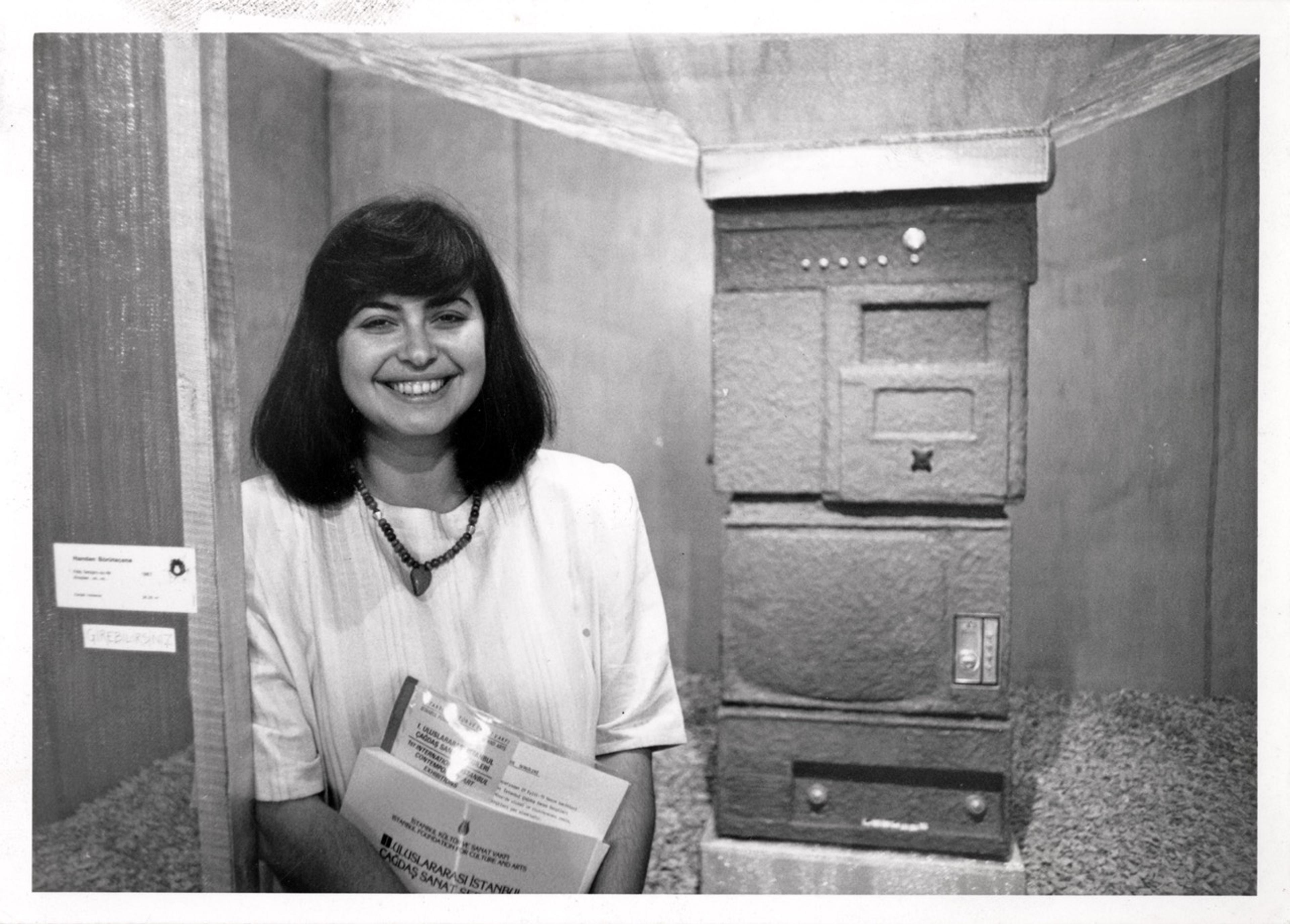 Handan Börüteçene, in front of her work Kitle İletişimsizlik Araçları vs vs zzzz….bızzzz [Mass Miscommunication Tools etc etc zzzz….bızzzz] (1987), 1st International Istanbul Contemporary Art Exhibitions, 1987 Courtesy the artist