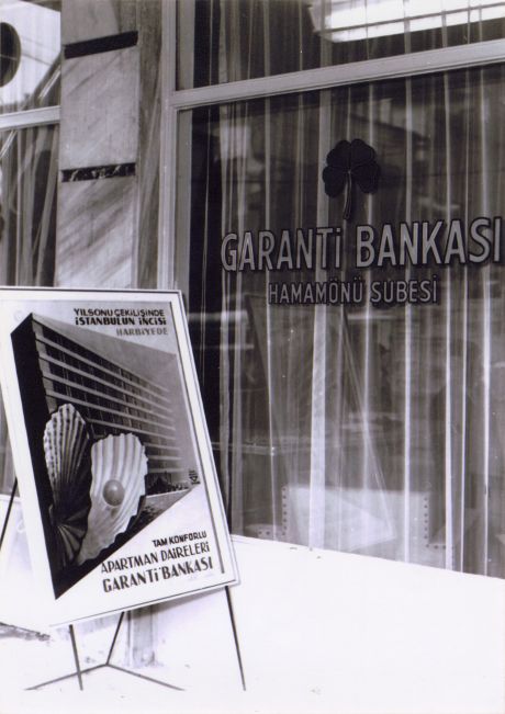 07 Gbph00508001 1950ler Garanti Bankası Hamamönü Şubesi (Ankara) ve önünde İhap Hulusi Görey’in tasarladığı apartman çekilişi afişi, 1950’ler
Salt Araştırma, Garanti BBVA Arşivi