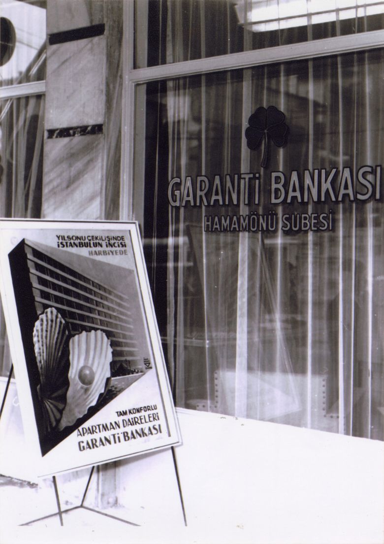 07 Gbph00508001 1950ler Garanti Bankası Hamamönü Şubesi (Ankara) ve önünde İhap Hulusi Görey’in tasarladığı apartman çekilişi afişi, 1950’ler
Salt Araştırma, Garanti BBVA Arşivi