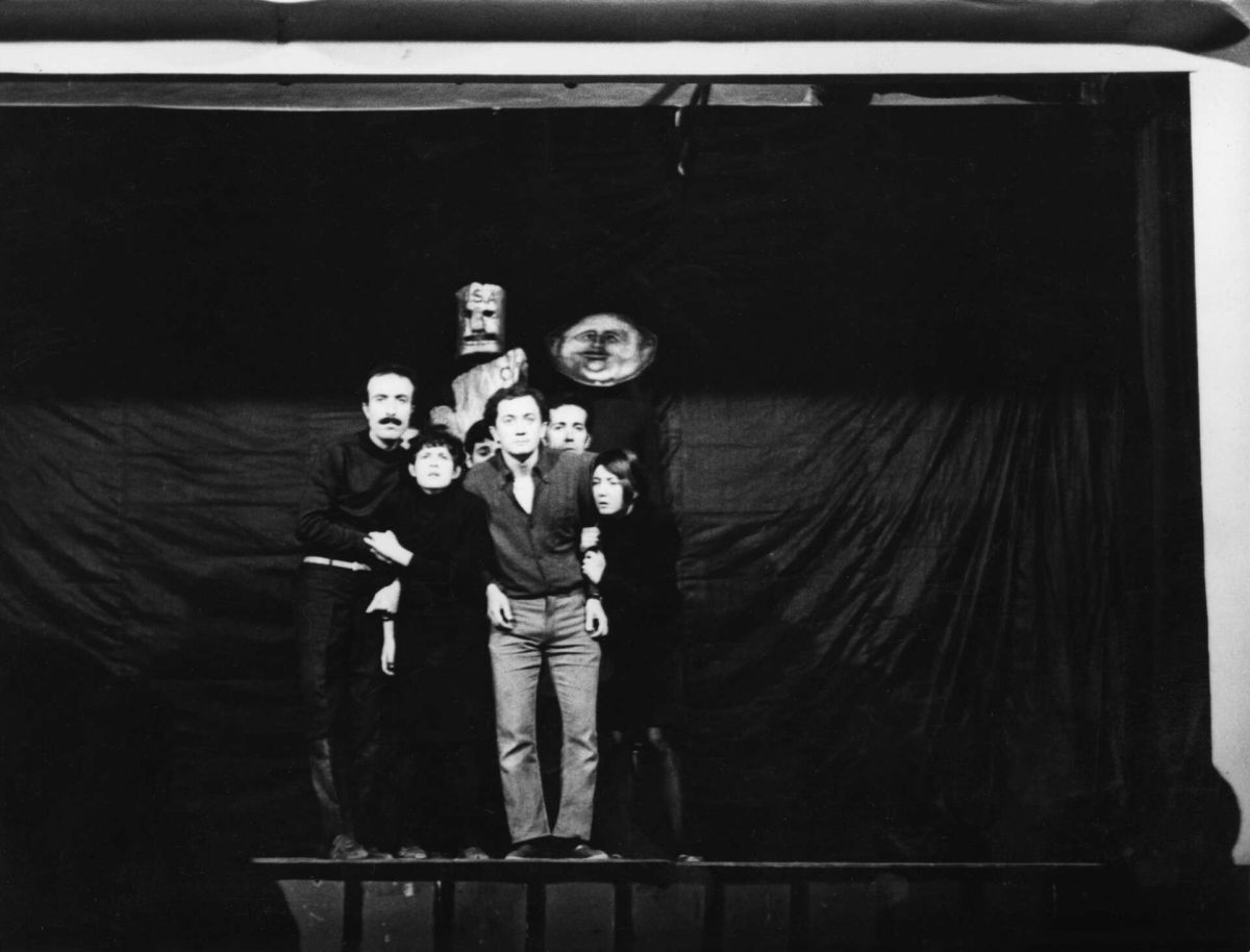 Gorsel 14 Sadık Karamustafa oyuncu olarak Devrim İçin Hareket Tiyatrosu’nun Aksaray’daki Türkiye Öğretmenler Sendikası (TÖS) Salonu’nda oynadığı <i>Amerika</i> oyununda, 1968-1971 <br />
Kadir Has Üniversitesi Ulusal Kültür Belgeliği Ali Özgentürk Arşivi<br />